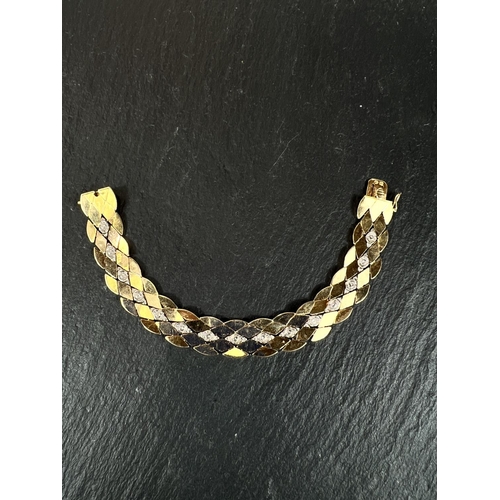 678 - A yellow metal bracelet formed from interlocking diamond shpaed links, bears foreign marks, tests as... 