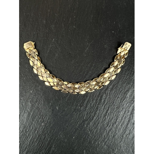 678 - A yellow metal bracelet formed from interlocking diamond shpaed links, bears foreign marks, tests as... 