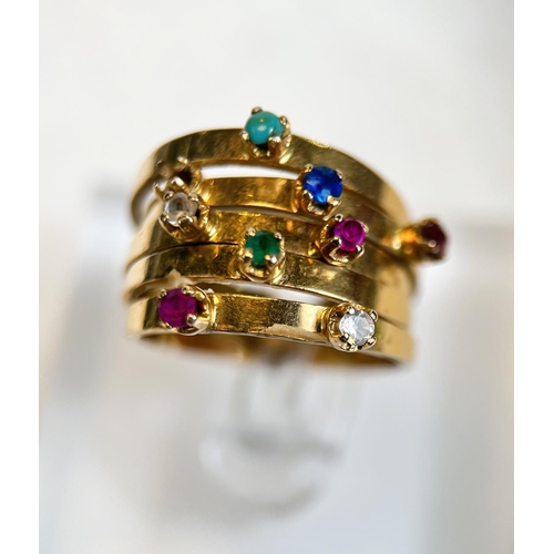 680 - A yellow metal ring with 5 adjoined shanks set with a total of 9 multicoloured stones including ruby... 