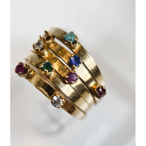 680 - A yellow metal ring with 5 adjoined shanks set with a total of 9 multicoloured stones including ruby... 