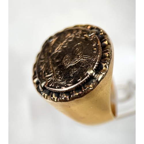 682 - A heavy yellow metal ring set with a small coin, shank tests as 18ct, gross weight 8.5m, size H