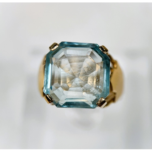 684 - A 1970's yellow metal dress ring with a large square cushion cut aquamarine colour stone in raised s... 