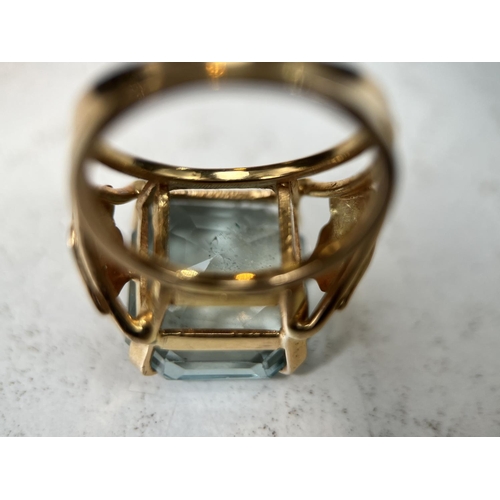 684 - A 1970's yellow metal dress ring with a large square cushion cut aquamarine colour stone in raised s... 