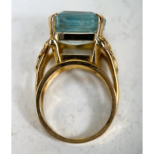 684 - A 1970's yellow metal dress ring with a large square cushion cut aquamarine colour stone in raised s... 