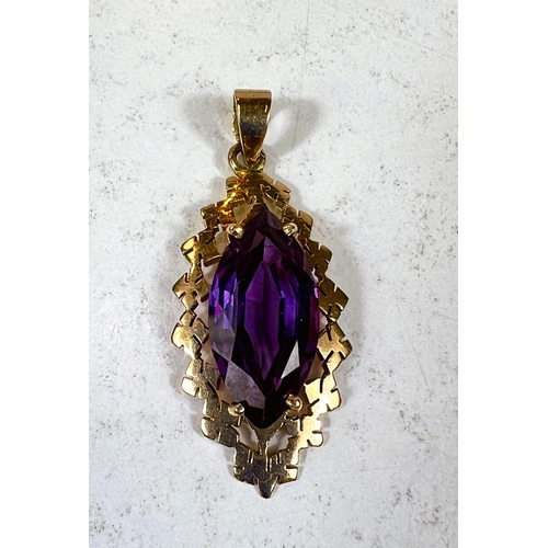 687 - A marquise cut purple / red amethyst stone set in yellow metal pendant stamped 18ct, length of stone... 