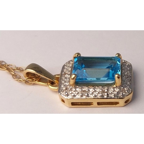 718 - A canted rectangular pendant set with a central cushion cut blue topaz surrounded by illusion set di... 