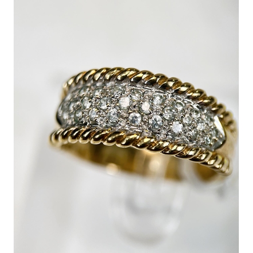 722 - A 9 carat hallmarked gold dress ring with multiple clear stones in split shank setting with rope twi... 