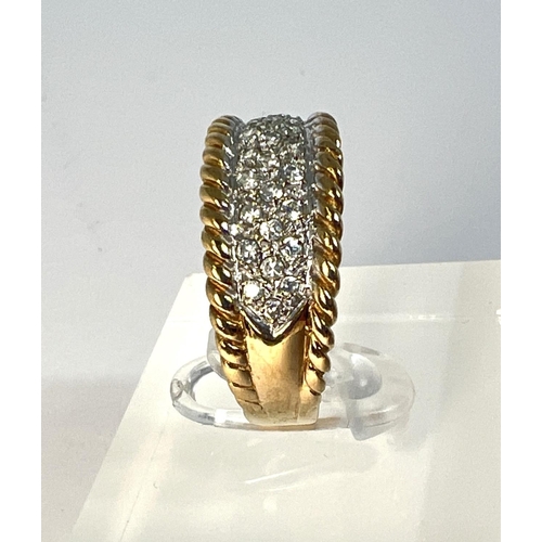 722 - A 9 carat hallmarked gold dress ring with multiple clear stones in split shank setting with rope twi... 