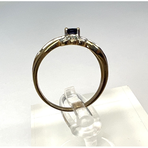 723 - A 9 carat hallmarked gold dress ring set with a blue stone, surrounded by clear stones, 3.4gm, size ... 