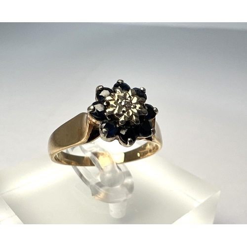 724 - A 9 carat hallmarked gold dress ring set with blue and clear stones in flowerhead setting, 2.8gm, si... 