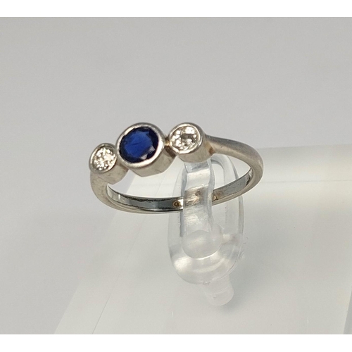 785 - A 1930's white metal ring set sapphire and 2 diamonds (tests 18ct), 3.19gm