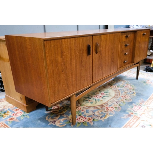 852 - A mid 20th century G-Plan 'Brasilia' teak long low sideboard with double cupboard and four drawers, ... 