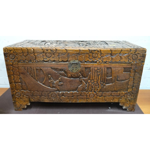 951 - An oriental camphor wood bedding box with extensive carved wood decoration, length