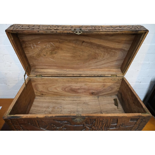 951 - An oriental camphor wood bedding box with extensive carved wood decoration, length