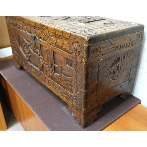 951 - An oriental camphor wood bedding box with extensive carved wood decoration, length