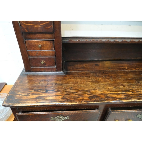 991 - An 18th/19th century oak dresser with 3 drawers below, rack and cupboards above with spice drawers