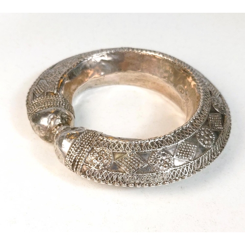 699 - AFRICAN TRIBAL BANGLE, 19th century white metal with applied decoration