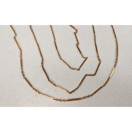 688 - A yellow metal chain formed from alternating elongated and multiple links, length approx. 80cm, test... 