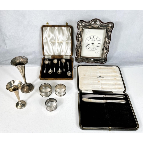 790 - A silver mounted mantle clock; a selection of silver teaspoons, cased; a posy vase and napkin rings.