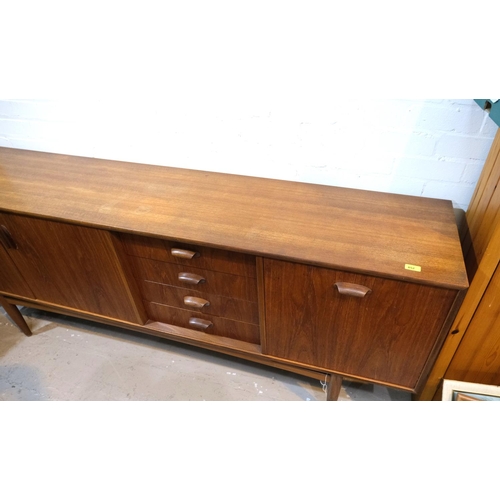 852 - A mid 20th century G-Plan 'Brasilia' teak long low sideboard with double cupboard and four drawers, ... 