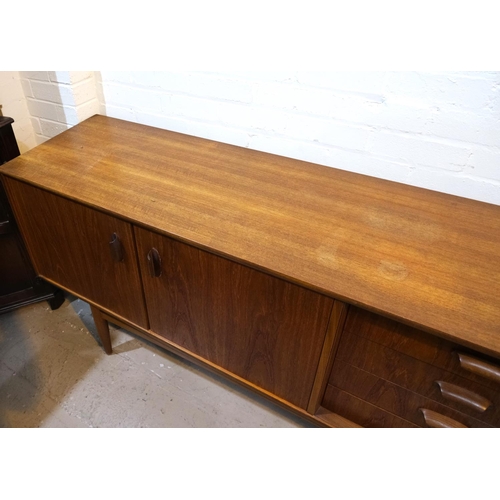 852 - A mid 20th century G-Plan 'Brasilia' teak long low sideboard with double cupboard and four drawers, ... 