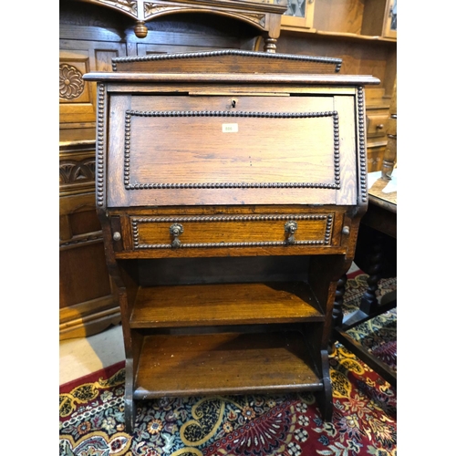 886 - A 1930's beaded oak fall front bureau with drawer and open shelves below