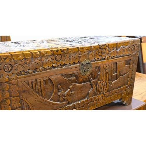 951 - An oriental camphor wood bedding box with extensive carved wood decoration, length