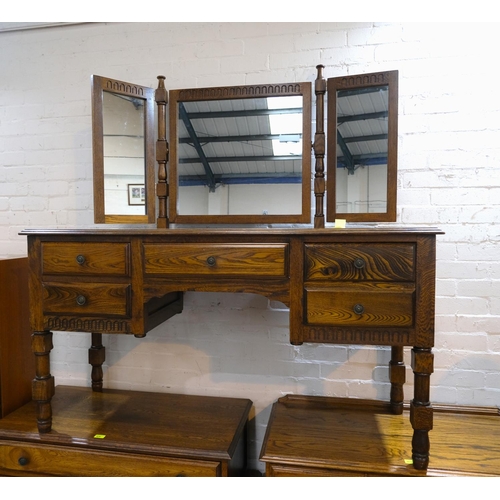 980 - A golden oak dressing table with triple mirror and five drawers below and a dressing stool, 144 x 50... 