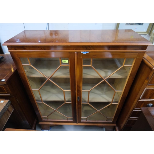 883 - A reproduction yew wood display cabinet enclosed by twin doors 