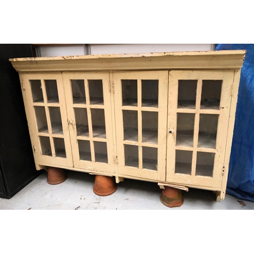 1003 - A painted pine kitchen wall hanging cabinet with glazed double doors, length 151cm