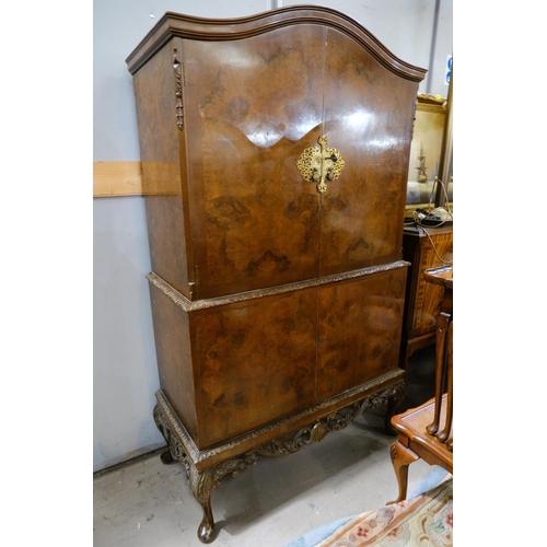 1011 - A burr walnut Queen Anne style cocktail cabinet with carved decoration, mirrored cupboard above, cup... 