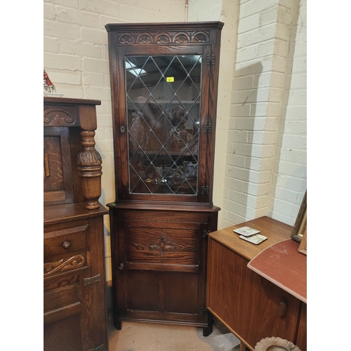 868 - An oak full height corner cupboard with leaded glass above and carved cupboard below