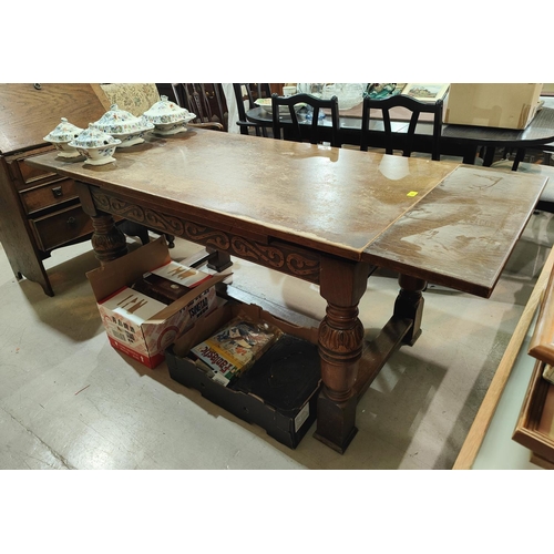 876 - An oak draw leaf dining table with carved bulbous legs, H stretcher and two draw leaves to each end