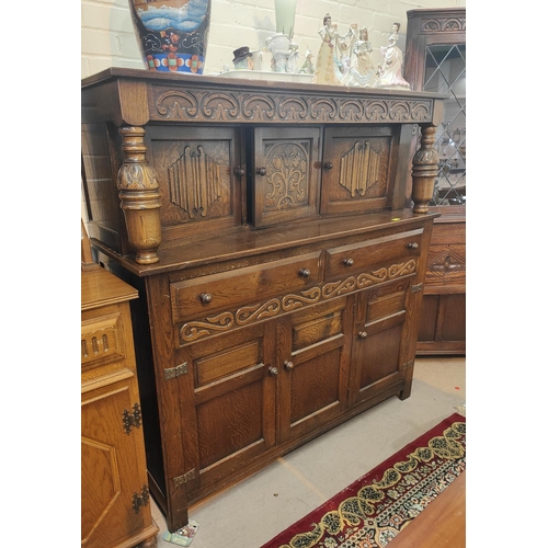 877 - An oak Jacobean style buffet sideboard with three cupboards below, two drawers above and three cupbo... 