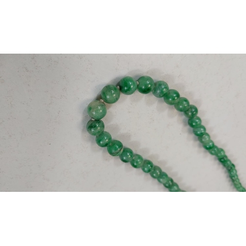 672 - GREEN JADE BEADS, a string of graduated beads, c. 1920, 50cm