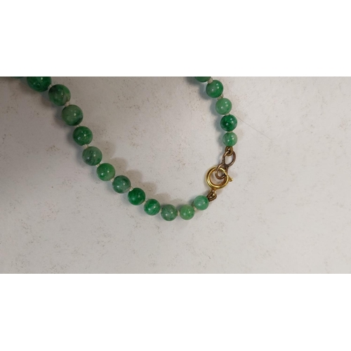 672 - GREEN JADE BEADS, a string of graduated beads, c. 1920, 50cm