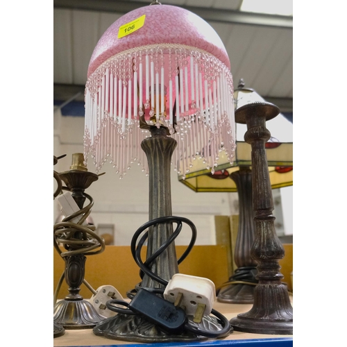 106 - An Art Nouveau style lamp base with pink glass and beaded fringe shade, 2 similar lamp bases and a c... 