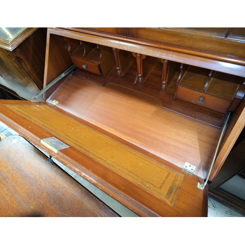 882 - A reproduction figured mahogany bureau/bookcase with 2 glazed drawers over fall front and four drawe... 