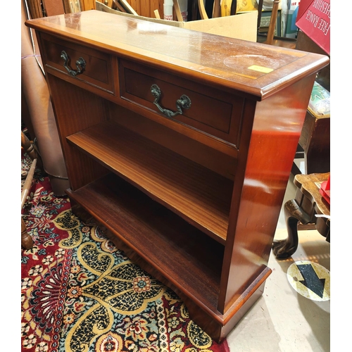 904 - A reproduction yew-wood dwarf bookcase with two drawers and two shelves.