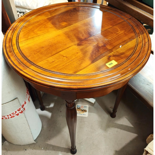 906 - A circular yew-wood effect occasional table on turned legs.