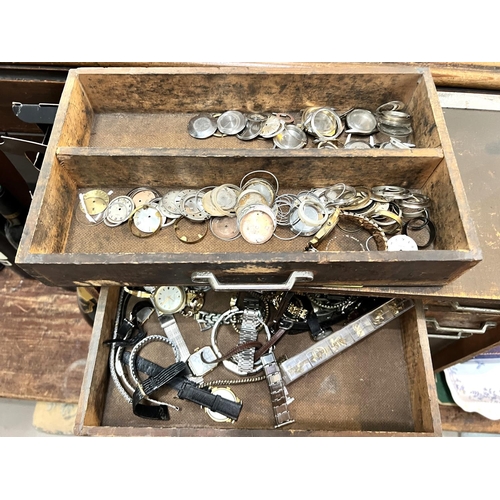 668 - A watch makers cabinet with a wide assortment of watches and watch parts