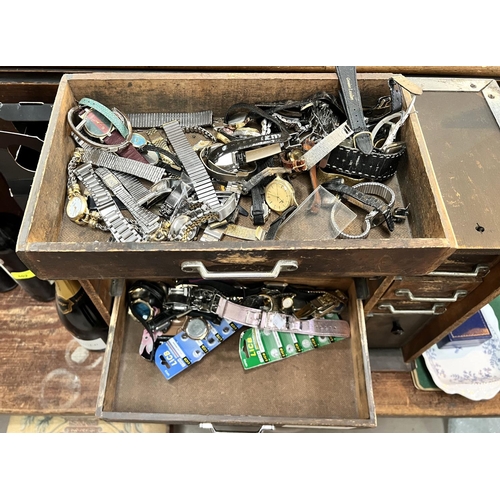 668 - A watch makers cabinet with a wide assortment of watches and watch parts