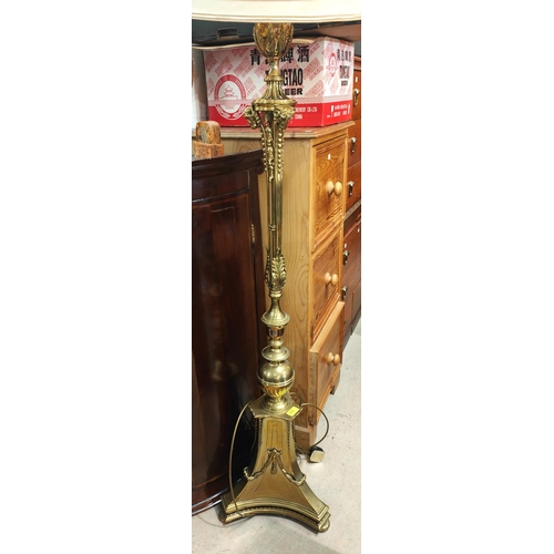 975 - An ornate brass standard lamp with ram mask mounts and trefoil base.