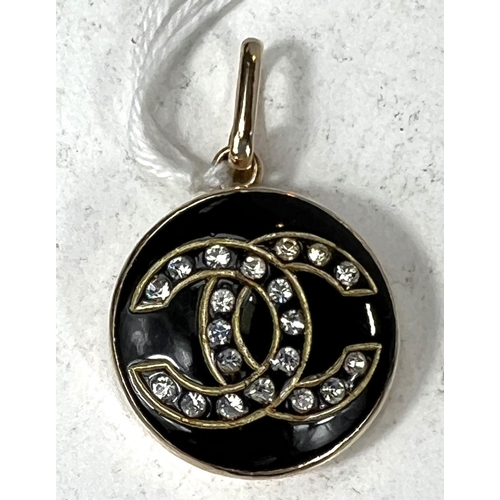 691A - A Chanel style pendant with yellow metal surround, black with clear stone 