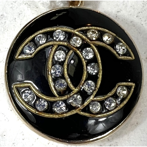 691A - A Chanel style pendant with yellow metal surround, black with clear stone 