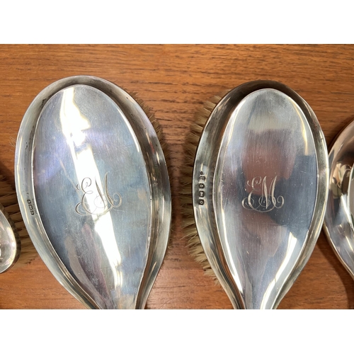 655 - A cased hallmarked silver, 4 piece, engine turned dressing table set, Birmingham 1915 and similar mi... 