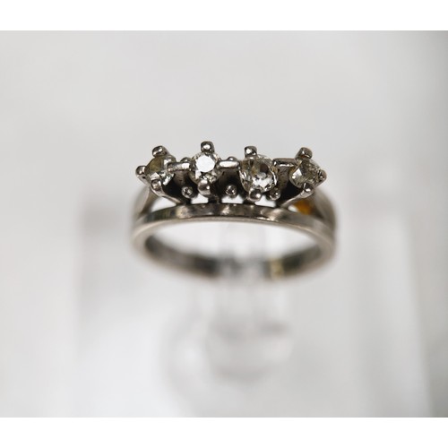 679 - A white metal ring stamped 18ct with 4 diamonds in split shank raised mounts, the centre stones appr... 