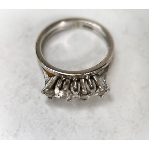 679 - A white metal ring stamped 18ct with 4 diamonds in split shank raised mounts, the centre stones appr... 