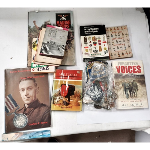 255 - A collection of military cap and other badges, some cloth examples and hard back military books etc