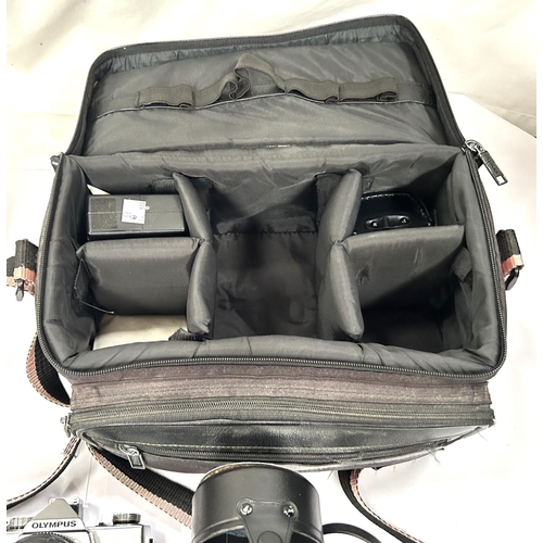 29B - An Olympus SLR camera with various lenses, accessories and bag.